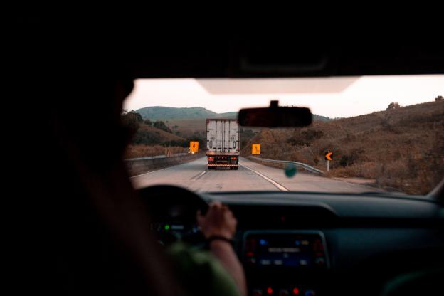 Truck Driver Workers Comp Insurance Photo of a person driving a vehicle behind a truck